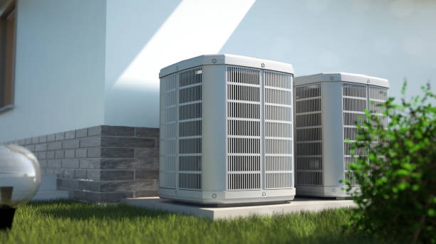 2 Air conditioning units on a cement slab next to a home.